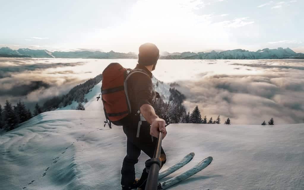 Man atop mountain taking selfie